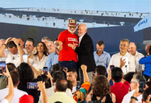 Funcionários da JBS de Campo Grande pedem ajuda a Lula por reajuste salarial durante discurso.